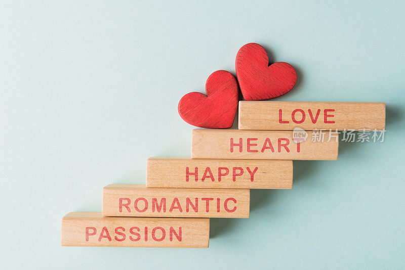 Wooden blocks with words Love, Heart, Happy, Romantic, Passion and two red hearts. Valentineâs day greeting concept
